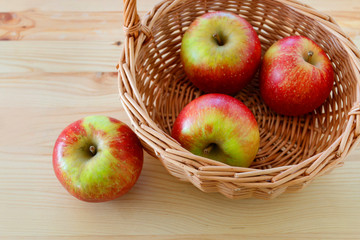 Basket with apples on wooden table