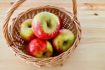 Basket with apples on wooden table