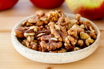 Bowl of walnuts and apples in the background.