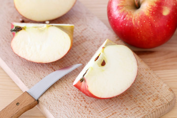 Red and yellow apples on wooden table.