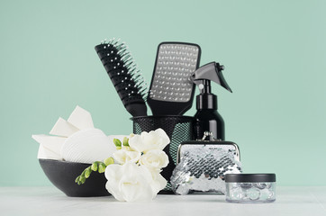 Black accessories and cosmetics for bathing and shower white fresh white flowers freesia in elegant...