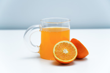 A glass of orange juice on the white table. A healthy and delicious orange juice.