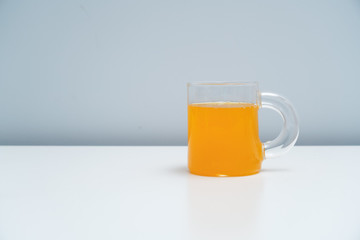 A glass of orange juice on the white table. A healthy and delicious orange juice.
