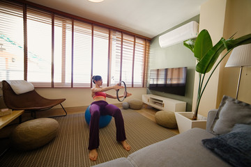 woman practicing yoga in her apartment in front of the window