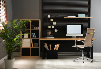 Comfortable workplace with computer and office chair. Stylish room interior