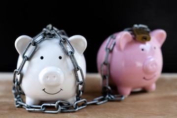 Piggy bank locked, chained with black background, Protect savings, Protect capital, Protect retirement fund concept