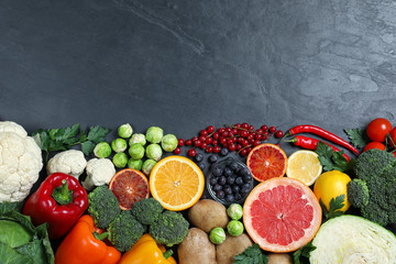 Different products rich in vitamin C on black table. Space for text