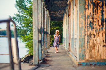 Fototapeta na wymiar little girl standing on porch of old ruined house.