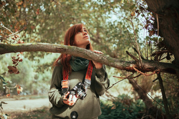Young woman observing the forest with an old camera