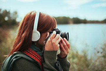 Young woman taking photos in the forest with an old camera