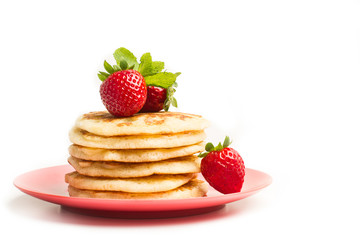 Tortitas con fresas y hojas de menta sobre un plato rosa redondo sobre un fondo blanco aislado. Vista de frente. Copy space