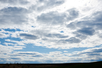 Light blue sky with white and grey clouds before the rain. Nature protection concept. Sunny day, warm weather.