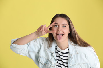 Fototapeta premium Portrait of funny young woman on yellow background
