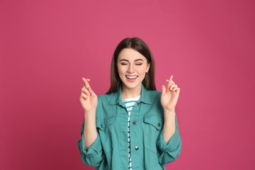 Portrait of happy young woman on pink background