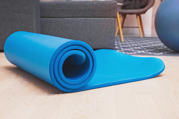 Fototapeta na wymiar Close up of yoga, fitness floor mat in modern living room