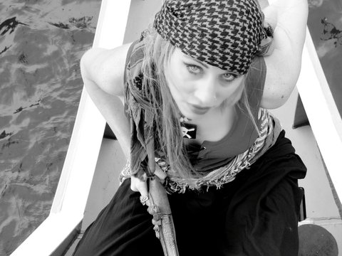 High Angle Portrait Of Woman In Pirate Costume Sitting On Boat Over Rivers