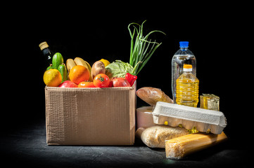 Food donations of different products on dark background, top view with copy space