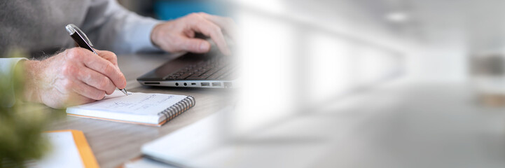 Businessman taking notes on notebook; panoramic banner