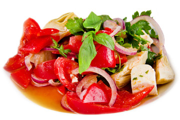 Vegetable salad of tomatoes, peppers, artichokes and onions. Close up. Front view.