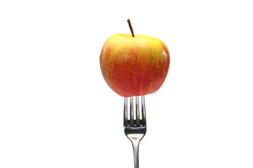 apple on fork on a white background. One ripe organic, juicy, fragrant apple with a metal fork, close-up, on a white background.