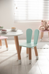 Small table and chair with bunny ears indoors. Children's room interior