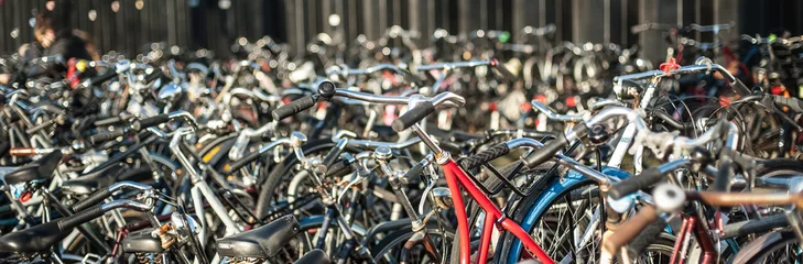 Foto auf Glas Gruppe von vielen alten holländischen Vintage-Klassiker-Fahrrädern, die in der Öffentlichkeit am Parkplatz geparkt sind. Blick auf das Stadtbild. Niederländischer Lebensstil © guruXOX