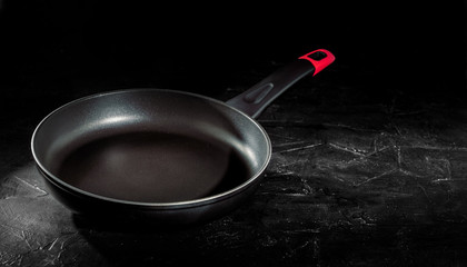 Empty frying pan on dark background