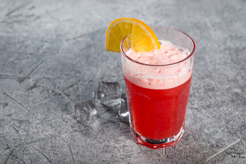 Drink fruit drink from berries with a slice of orange in a glass transparent glass