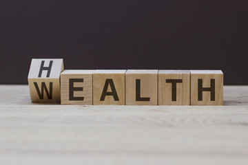 wooden cubes form the words wealth and health