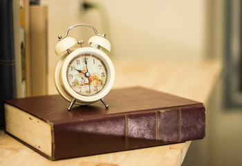 Educational concept Alarm clock with old books