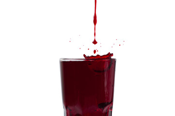 Grape and pomegranate juice pouring into a glass, isolate on a white background
