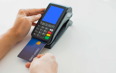 Paying with a credit card for a man's hand, put a credit card into a card reader to pay instead of cash.