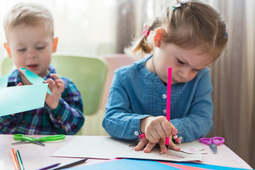 A mother with a child sits at the table and does homework. The child learns at home. Home schooling.