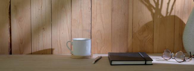 Fototapeta na wymiar Close up view of modern rustic workspace with notebook, coffee cup, supplies and copy space