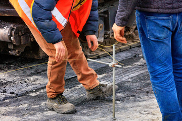 Workers set the necessary level for the subsequent asphalting of a new section of the road.