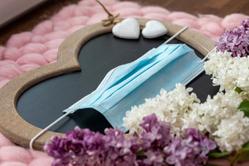 Herz zum Muttertag mit Maske zum Mundschutz vor Corona und Blumen