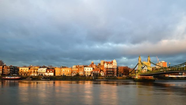 A west London timelapse scene of the north bank of the River Thames including Hammersmith Bridge and attractive riverside buildings