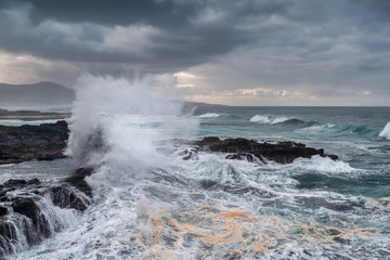 Paisaje marino  de la Playa del Puertillo con una gran ola rompiendo en las rocas. Arucas. Gran...