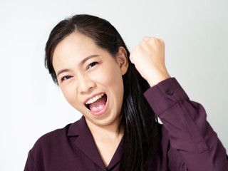 Asian business woman is happy and cheerful emotion acting. Marketing selling target is successful. Lady wear purple office shirt. Female show hand, lough and smile see teeth. Pink nude makeup tone.