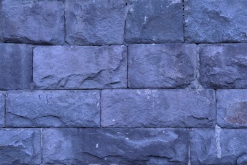 Rough uneven brickwork of gray color.