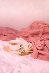 Fototapeta na wymiar Pausa relax con libro, tè caldo e peonie rosa