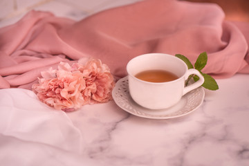 Pausa relax con libro, tè caldo e peonie rosa