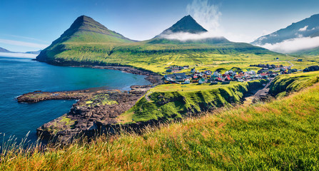 Fantastic morning view of Gjogv village. Sunny summer scene of Eysturoy island. Nice seascape of Atlantic ocean, Faroe Islands, Denmark, Europe. Traveling concept background.