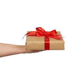 hand hold a wrapped gift in brown craft paper with tied silk red bows, subject is isolated on a white background