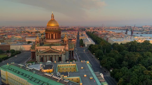 Aerial sideways Saint Petersburg sunrise central cityscape St. Isaac's Cathedral museum. Historical downtown. Largest church Russia. Old streets. Neva river, divorced bridge. River port on horizon