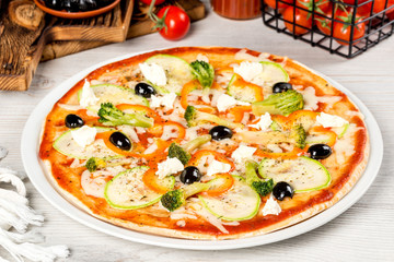Pizza with olives on a white plate shot in the decor