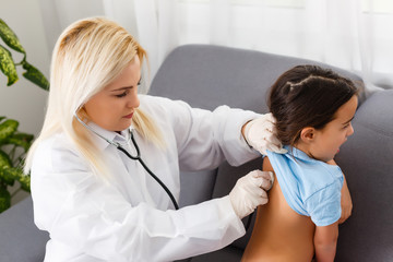 Doctor examining a little girl by stethoscope. Medicine and health care concept.