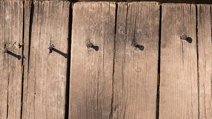 Background of old dirty boards. Old rotten planks of the bridge over the stream. Dust-covered wood.