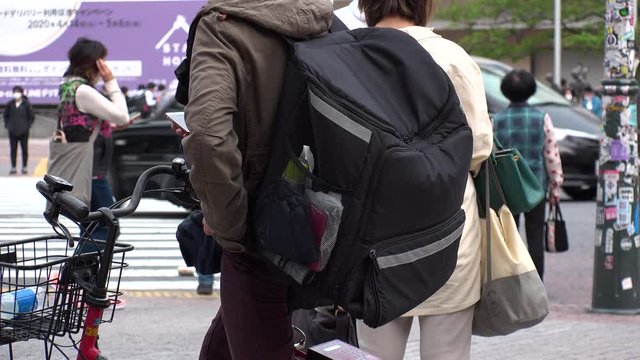 TOKYO, JAPAN : Close up shot of food delivery bag at the street. Large black box backpack to carry food or drinks from restaurant and cafe to customers.
