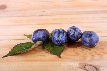 Blue plums on table